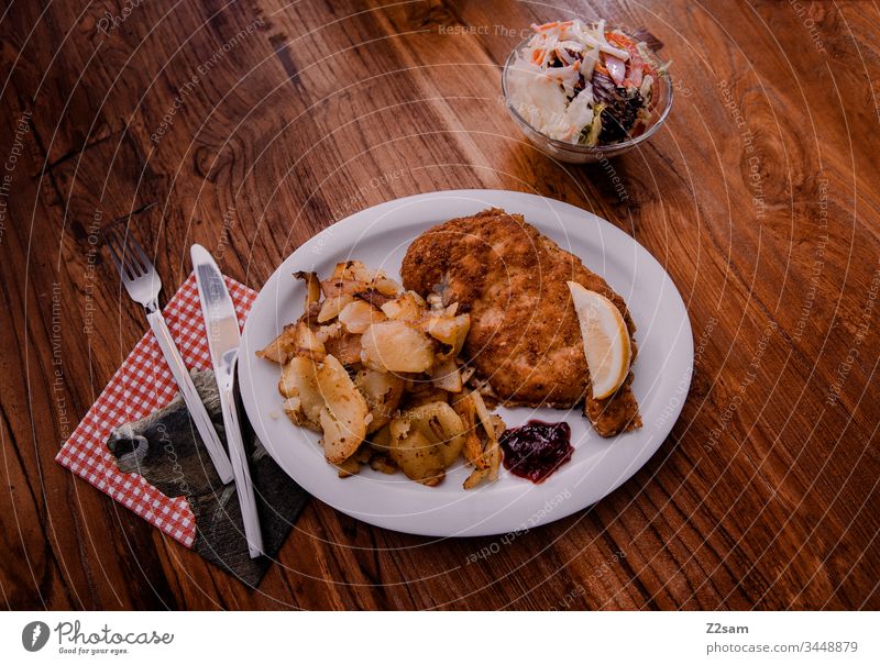 Wiener Schnitzel mit Bratkartoffeln bratkartoffeln bayern österreich gericht bodenständig essen genuss salat fleisch paniert ernährung food rustikal Farbfoto