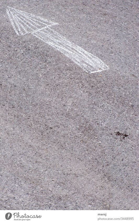 Ein Pfeil, gezeichnet mit Kreide, auf Asphaltstrasse, der ins linke obere Eck zeigt. richtungsweisend Richtung Hinweis Gedeckte Farben Kontrast Wege & Pfade