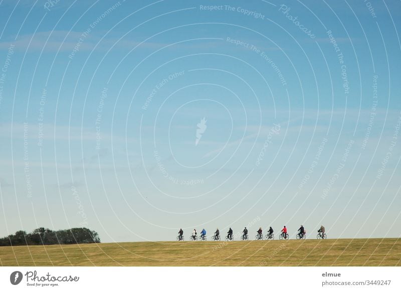 11 Radfahrer fahren hintereinander auf einem Damm radfahren Gruppe elf schönes Wetter Himmel himmelblau Abstand Ausflug Sport Außenaufnahme Gesundheit Natur