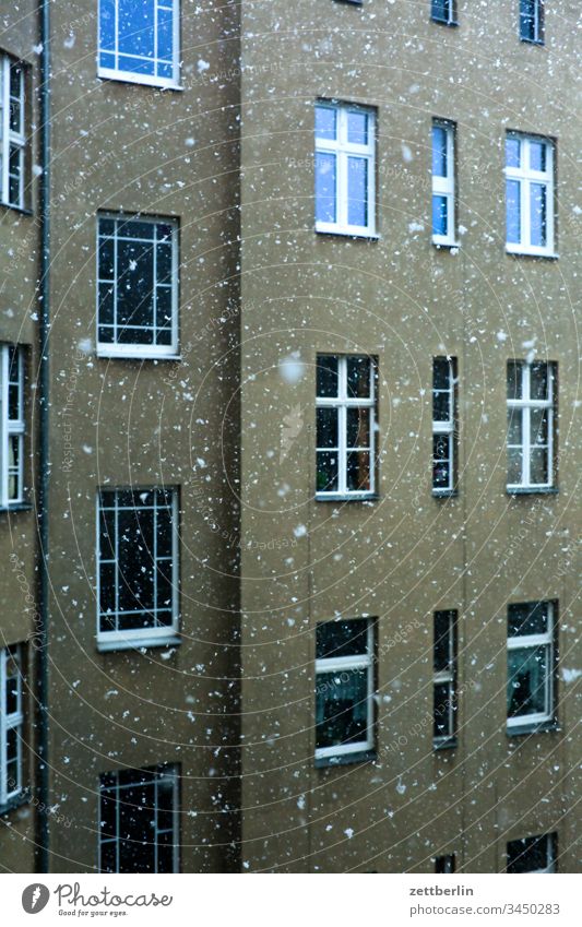 Schneefall im Hinterhof altbau außen fassade fenster haus hinterhaus hinterhof innenhof innenstadt mehrfamilienhaus menschenleer mietshaus schnee schneefall