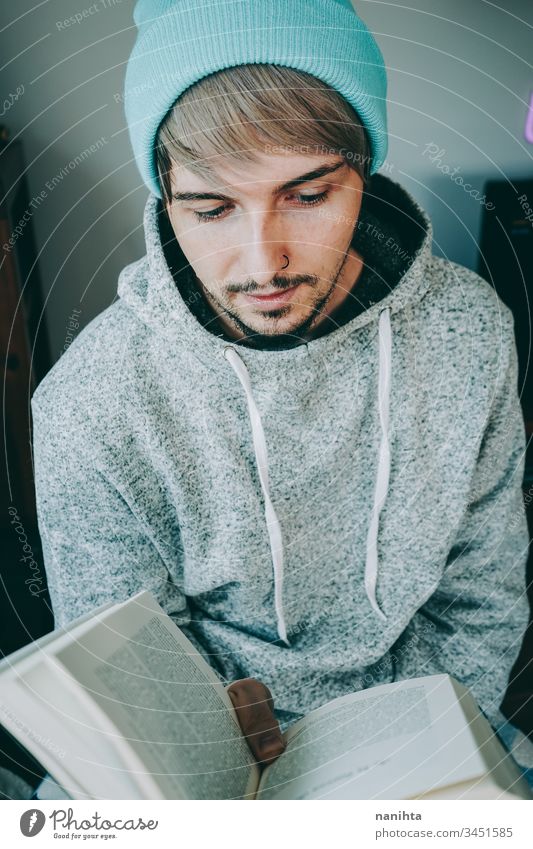 Junger Mann liest ein Buch in seinem Haus lesen heimwärts attraktiv Quarantäne Hobby Freizeit sich[Akk] entspannen genießend lernen Schüler jung Jugend