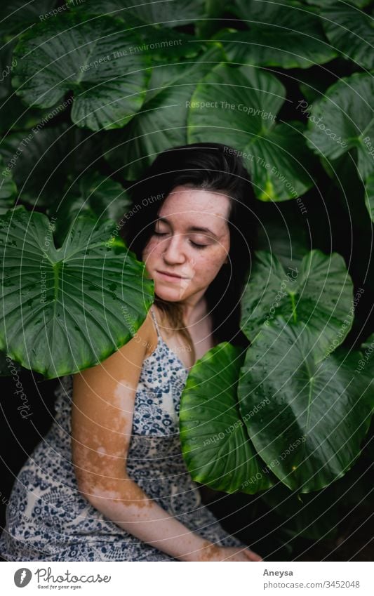 Eine junge Frau umgeben von Blättern 2017-2020 erste Einfuhr Elefantenohr Elefantenohrpflanze Garten Junge Frau Wetter Tropenpflanze tropisch geblümt