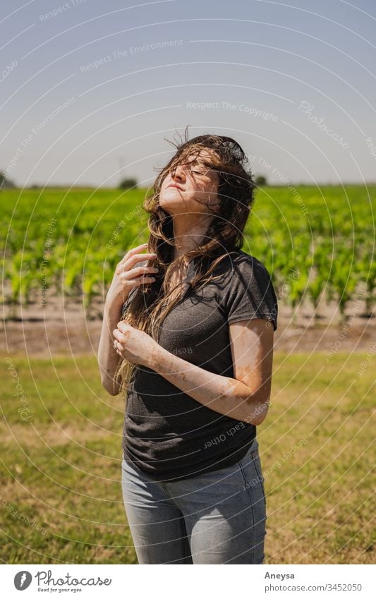 Eine junge Frau draußen an einem windigen Tag 2017-2020 erste Einfuhr Wind schmutziges Haar unordentlich Zufriedenheit Fröhlichkeit windiges Wetter windiger Tag