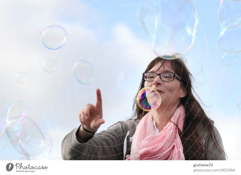 Glückliche, junge Frau spielt mit Seifenblasen Junge Frau Farbfoto Außenaufnahme Tag Blauer Himmel Lächeln Gute Laune Freude Fröhlichkeit Kindheitserinnerung