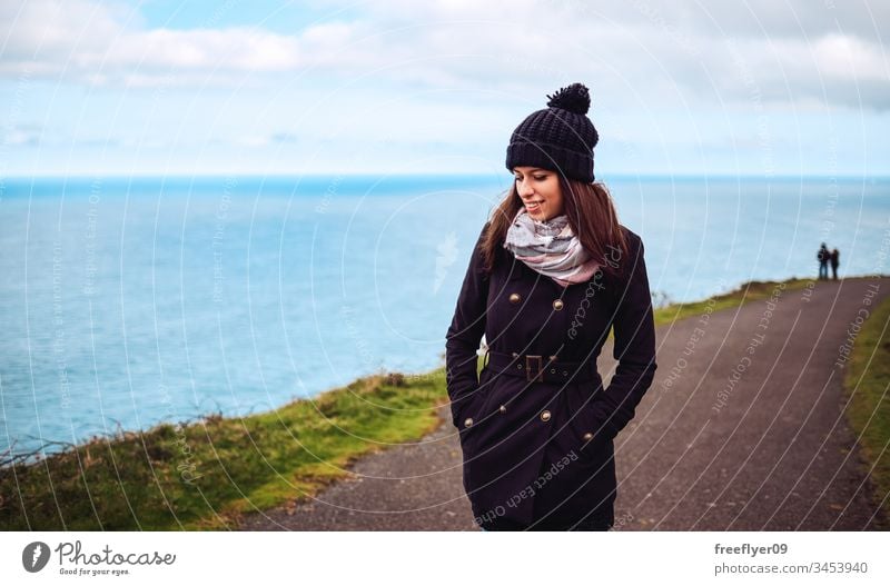 Porträt einer jungen Frau im Winter beim Spaziergang am Meer Abenteuer attraktiv Herbst weg Rücken Hintergrund schön Schönheit hinten schwarz Kleidung kalt