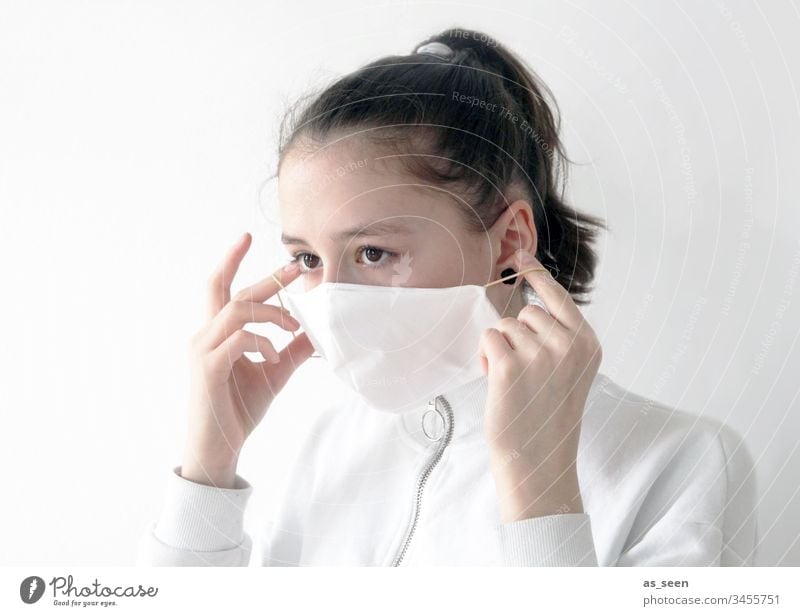 Mädchen setzt Mundschutz auf Atemschutz Atemschutzmaske Maske Mensch Farbfoto 1 Angst Schutz bedrohlich gefährlich Krankheit Coronavirus Infektionsgefahr Virus