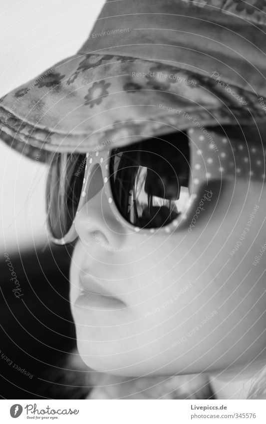 M.M.W. Kind Mensch feminin Kleinkind Mädchen Kopf 1 1-3 Jahre Stoff Brille Sonnenbrille Mütze schwarz weiß Schwarzweißfoto Innenaufnahme Detailaufnahme