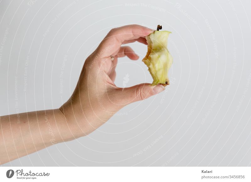 Hand hält Kerngehäuse von einem Apfel kerngehäuse halten hand gesund essen abgebissen obst diät saftig apfelkern süß weiß gesundheit frisch close up angebissen