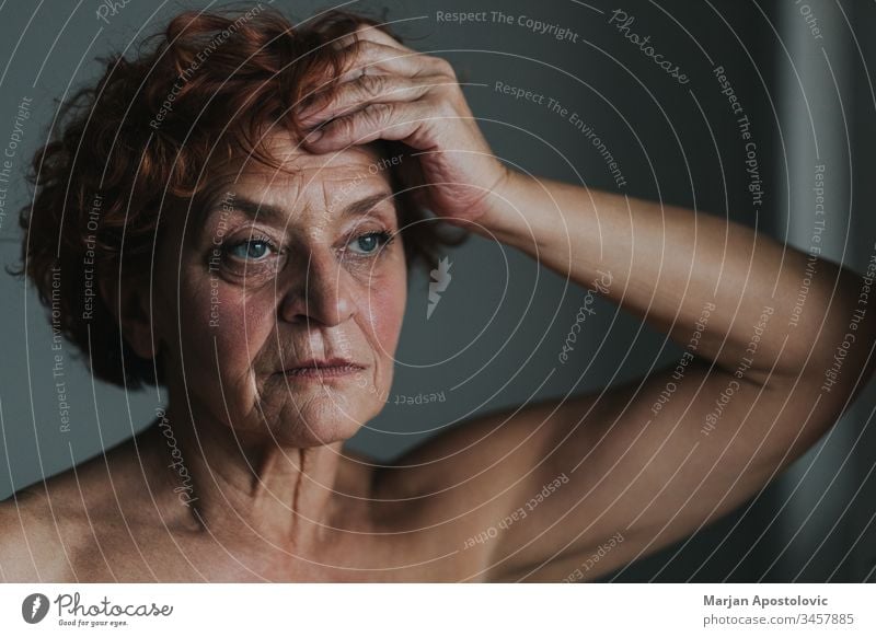 Reife Frau am Fenster, die über das Leben nachdenkt 60s Erwachsener Lebensalter gealtert Alterung allein schön Pflege Kaukasier Nahaufnahme Ansteckung