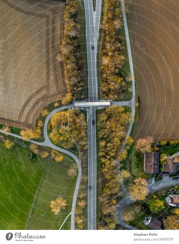 Eine von Autos befahrene Straße mit Brücke aus der Vogelperspektive mit einem Copter aufgenommen Luftaufnahme Menschenleer Außenaufnahme Tag Verkehrswege