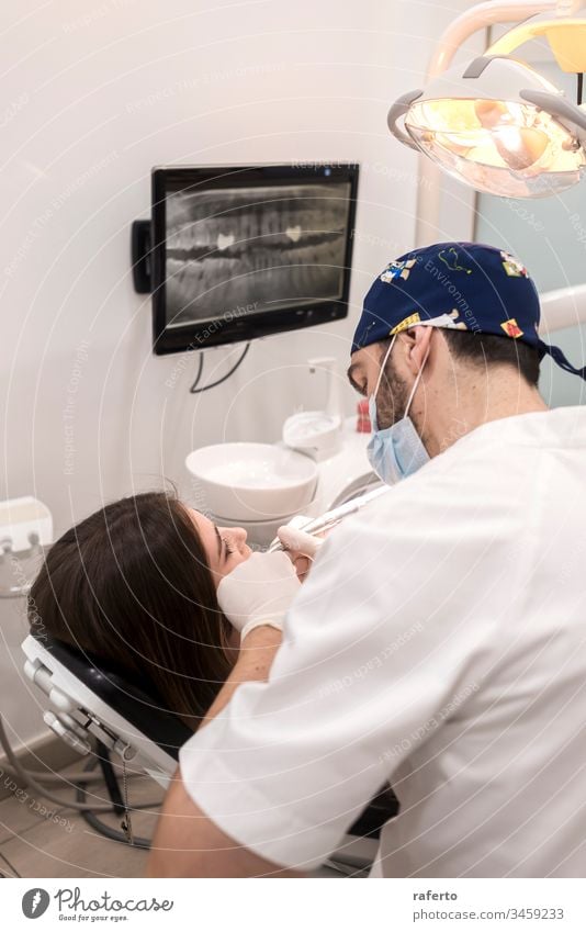Junger bärtiger Zahnarzt bohrt der Patientin einen Zahn jung geduldig Medizin Frau Kieferorthopäde Behandlung Mund Gesundheit dental Bohrung Zahnmedizin