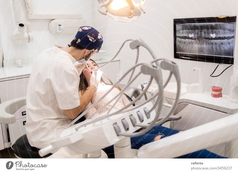 Junger bärtiger Zahnarzt bohrt der Patientin einen Zahn jung geduldig Medizin Frau Kieferorthopäde Behandlung Mund Gesundheit dental Bohrung Zahnmedizin