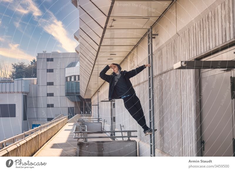 junger Mann, der auf einer Leiter herausschaut schön Junge Gebäude lässig Kaukasier Klettern Beton selbstbewusst Auge Hand Laufmasche Lifestyle Blick