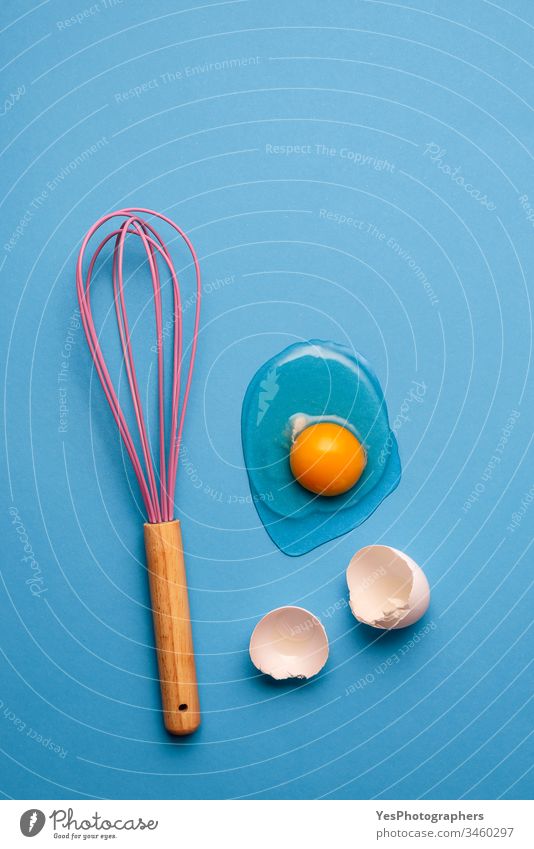 Knick-Ei und Schneebesen als Backkonzept. backen blau Sauberkeit farbenfroh Konzept Essen zubereiten Knickerei Eigelb Eierschalen flache Verlegung Lebensmittel