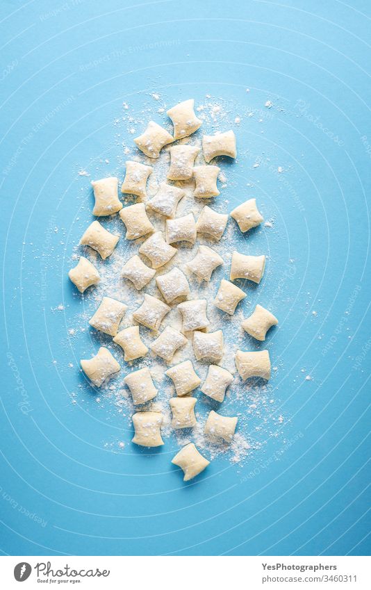 Haufen ungekochter Gnocchi. Käse-Gnocchi-Knödel auf Mehl Italienisch obere Ansicht Blauer Hintergrund Essen zubereiten Küche Abendessen Europäer