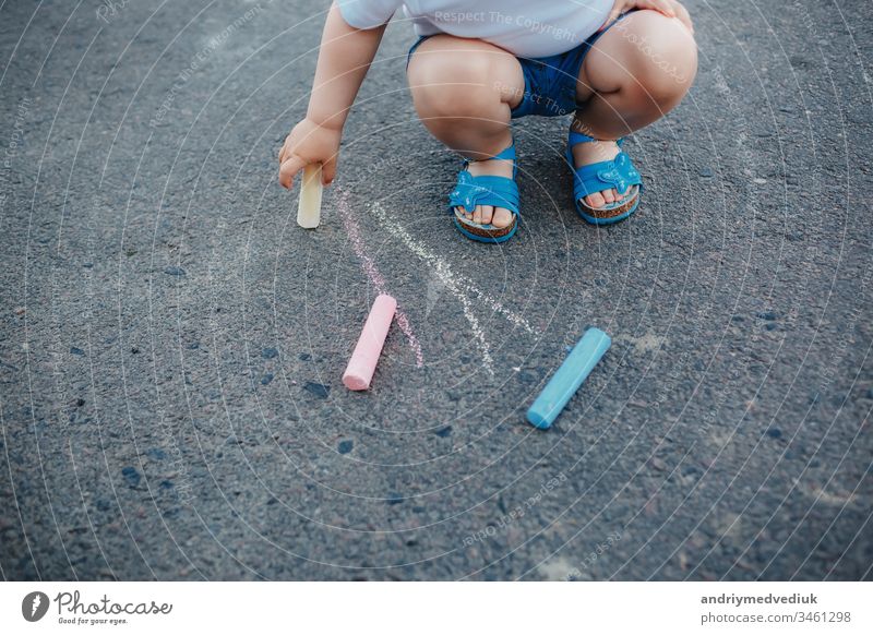 Nahaufnahme einer Zeichnung eines kleinen Mädchens mit Kreiden auf dem Bürgersteig Farbe Hand Straßenbelag wenig Kunst Sommer Hintergrund farbenfroh Spaß