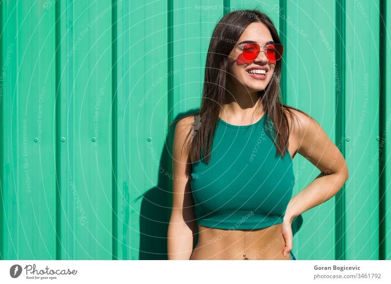 Trendige junge Frau steht an der grünen Wand Erwachsener attraktiv schön sorgenfrei lässig Kaukasier Großstadt Kleidung Farbe Selbstvertrauen cool niedlich