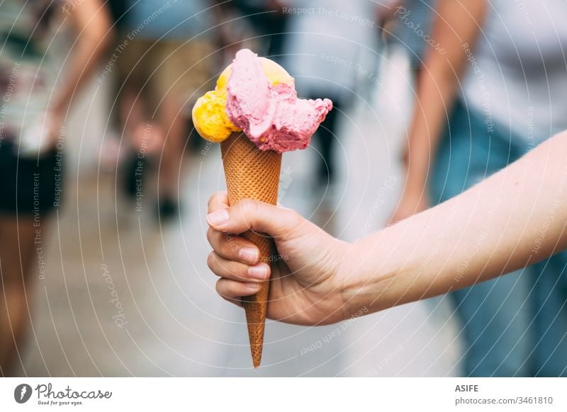 Eiscreme ist der beste Snack im Sommer Speiseeis Zapfen Hand Baggerlöffel Waffel Beteiligung Straße Menschen im Freien Frau eine Mangofrucht Erdbeeren kalt
