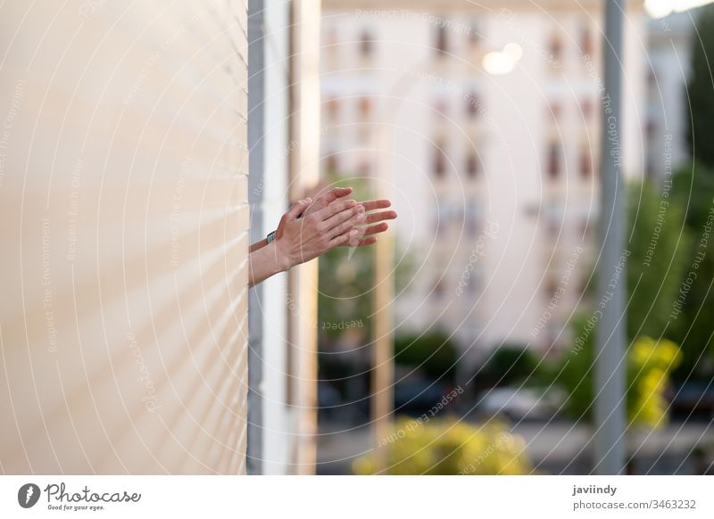 Frau klatscht in das Fenster zur Unterstützung der Menschen, die gegen das Coronavirus kämpfen Klatschen Seuche Virus Balkon Mädchen Gesundheit Gebäude weltweit