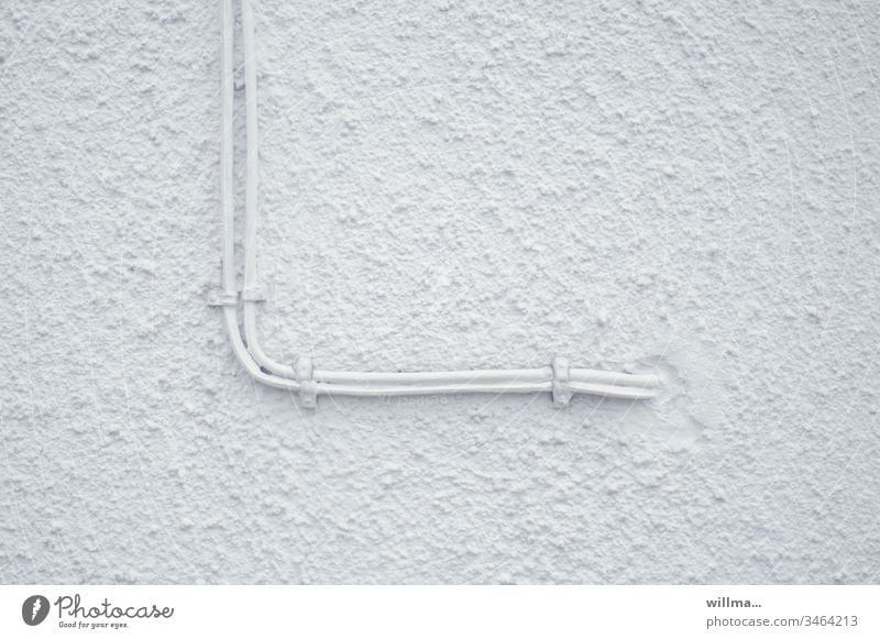 Aufputzinstallation Kabel Wand Leitung Elektrizität auf Putz minimalistisch Putzfassade weiß Textfreiraum Fassade Hauswand verputzt