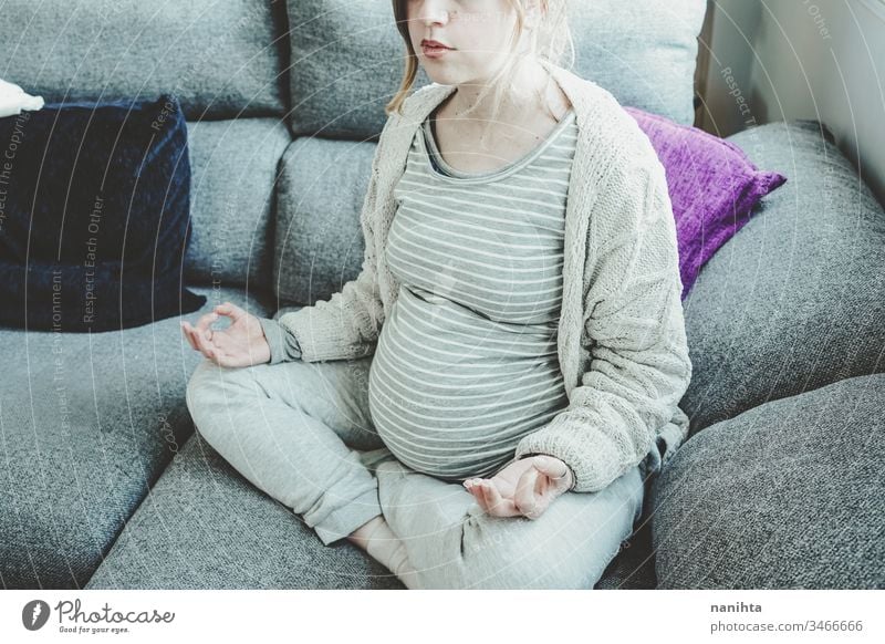 Junge schwangere Frau macht Yoga zu Hause Schwangerschaft Mama heimwärts Familie Quarantäne Erholung Meditation Frieden zu Hause bleiben Lügen