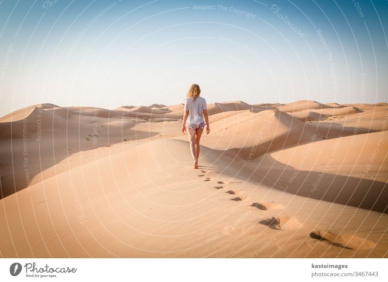 Blonde kaukasische Reisende hinterlässt beim Wüstenspaziergang im Oman Fußspuren in den Sanddünen Fußstapfen Dessert Ferien & Urlaub & Reisen Natur