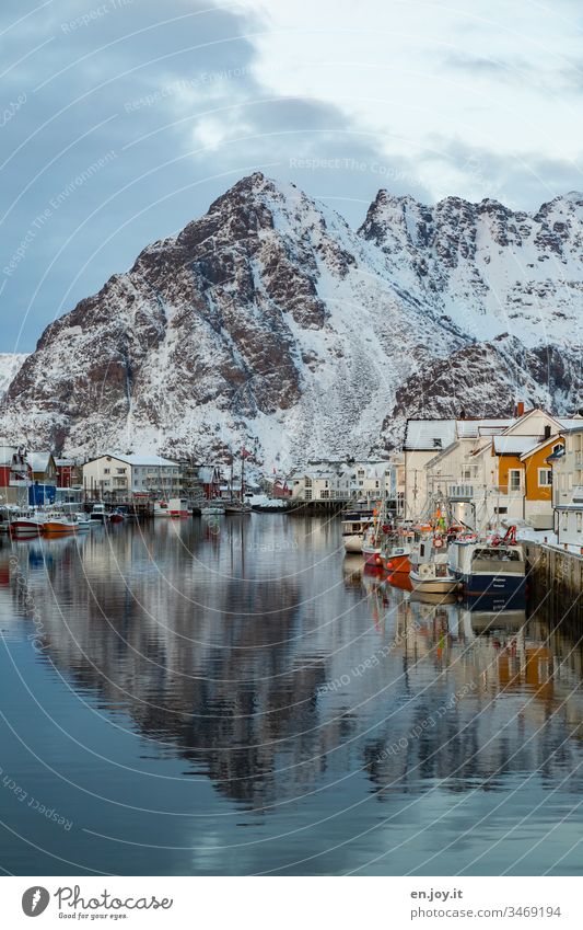 Hafen mit Booten und Häusern mit Spiegelung vor schneebedeckten Bergen in Hennigsvaer Henningsvær Lofoten Lofoten Inseln Norwegen Natur Norwegen 2015