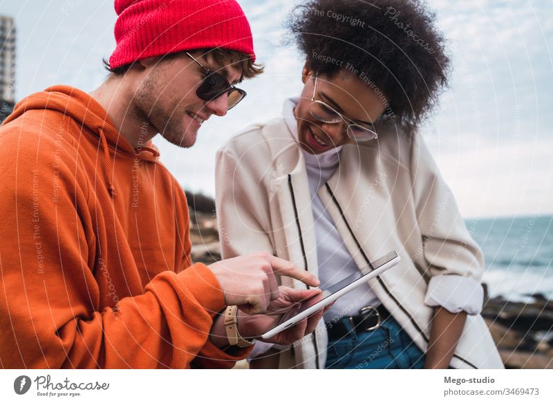Zwei Freunde verwenden ein digitales Tablett. Tablette im Freien jung Spaß Frau heiter Lifestyle Technik & Technologie Freundschaft pc Zusammensein Stehen