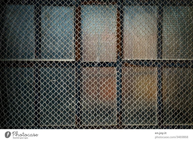 vergittertes Fenster eines alten Fabrikgebäudes Gitter verschlossen Glasscheibe schmutzig Sicherheit Schutz geschlossen Farbfotot Fensterkreuz Menschenleer