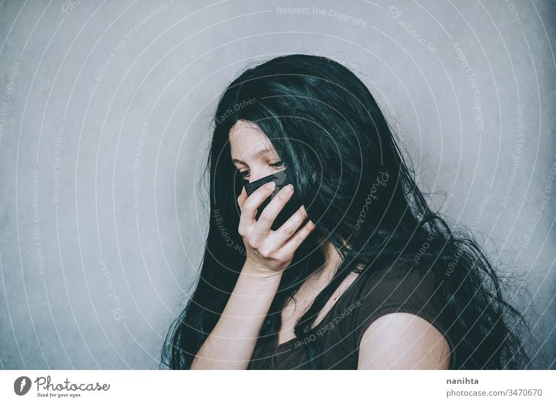 Traurige Frau mit schwarzer Gesichtsmaske COVID Bund 19 Corona-Virus Mundschutz Operationsmaske schützend Schutz Krankheit Infektion ansteckend Hand Trauer