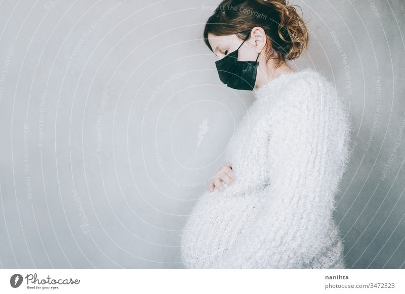 Junge schwangere Frau mit einer Maske während der Pandemie Covid 19 Bund 19 COVID coronarivus Schwangerschaft Grippe Mundschutz Mama Mutter Risiko Risikogruppe