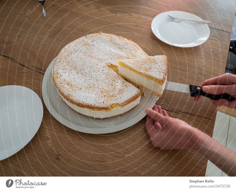 Schnitt eines cremigen Käsekuchens, von meiner Frau selbst gebacken. geschnitten Hand Aktion Messer verwenden Spielfigur Kuchen selbst gemacht Pasteten lecker