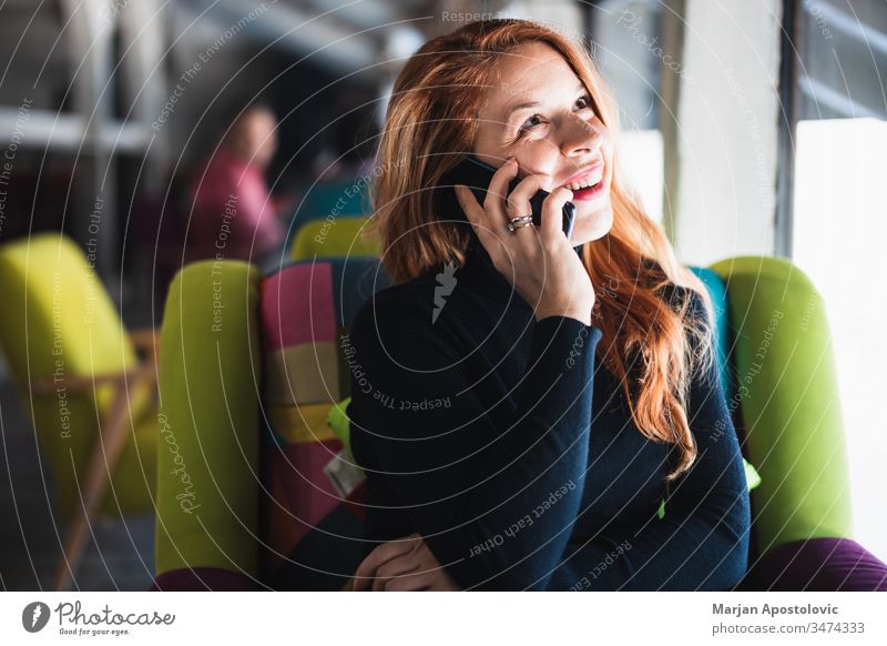 Junge glückliche Frau benutzt Smartphone in einem Cafe jung Glück Lächeln Café im Innenbereich lässig Tisch Sitzen Lifestyle verbunden Anschluss Mobile Telefon