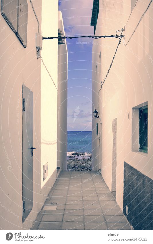 Blick aufs Meer zwischen zwei Häusern hindurch Meerblick Haus eng Durchblick Einschränkung Mauer Fassade Gasse Gebäude verbaut Menschenleer Architektur Wand