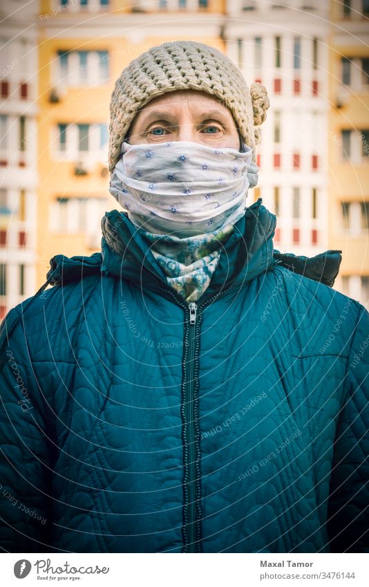 Eine arme ältere Frau trägt eine selbstgemachte Maske, um sich vor Viren zu schützen Erwachsener luftgestützt Atmung Gebäude Großstadt Ansteckung ansteckend