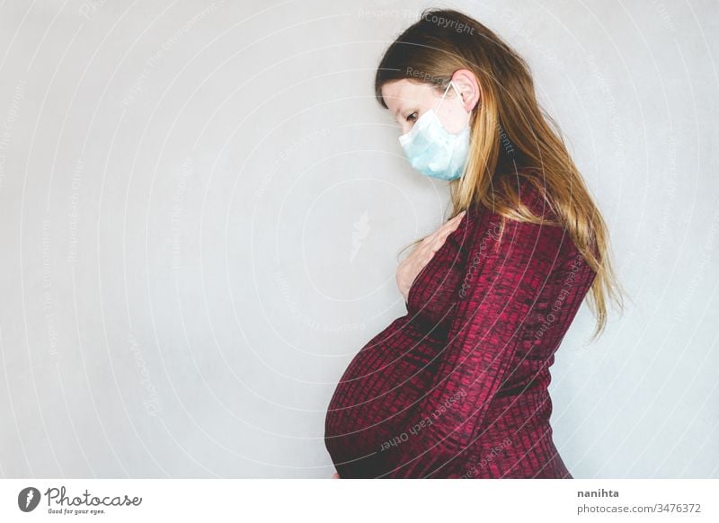 Junge schwangere Frau mit Gesichtsmaske Bund 19 COVID Grippe Mundschutz Coronavirus Pandemie Seuche Krankheit Schwangerschaft Risikogruppe Atemwegserkrankungen