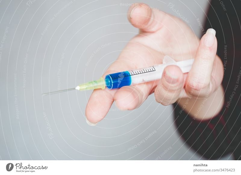Frauen halten eine Spritze in der Hand Bund 19 COVID Grippe Mundschutz Coronavirus Pandemie Seuche Impfstoff Erkundung Atelier Behandlung Medizin Medikament