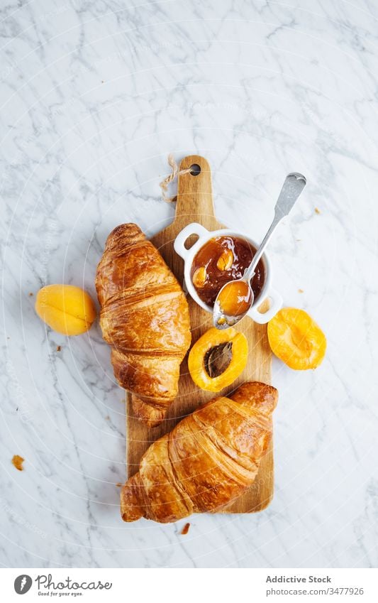 Croissant und Aprikosenmarmelade auf Holzbrett Marmelade Gebäck Frühstück backen frisch natürlich Morgen Lebensmittel dienen lecker geschmackvoll Mahlzeit