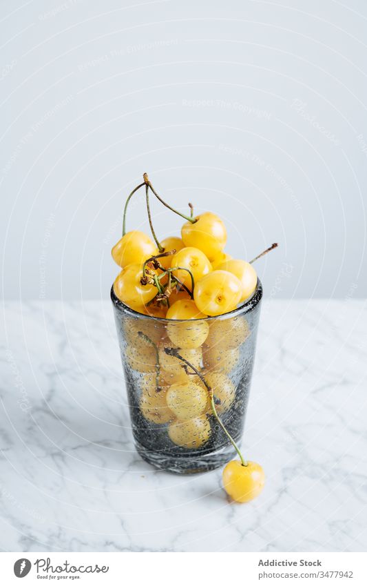 Glas mit gelben Kirschen auf dem Tisch Beeren Frucht frisch reif natürlich Lebensmittel Gesundheit satt Pflanze Stengel Vitamin süß geschmackvoll lecker roh
