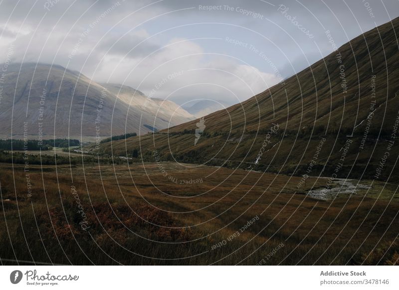Bewölkte Landschaft mit Hügeln und Fluss Hochland bedeckt wolkig Himmel Schottland Herbst Nebel Berge u. Gebirge Gras trist Natur malerisch reisen Tourismus Tal