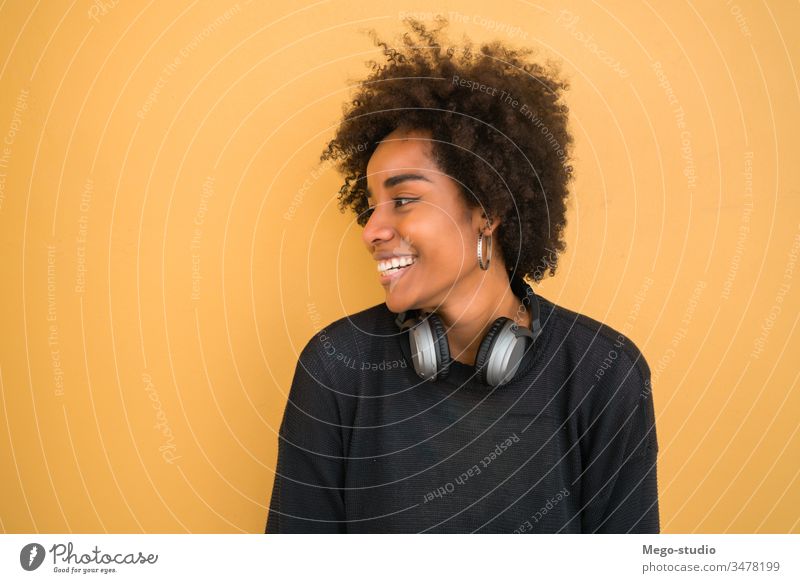 Porträt einer jungen afroamerikanischen Frau. Afro-Look schön gelb Hintergrund Erwachsener Frisur lieblich Wand Stehen Bild Aussehen gestikulieren heiter