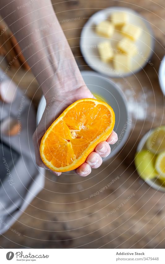 Frau zeigt halbe Orange über Schüssel orange Hände vorbereiten Rezept Bestandteil Küche Lebensmittel Koch selbstgemacht frisch Saft kulinarisch Gastronomie