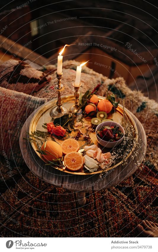 Tisch mit brennenden Kerzen und Früchten auf Tablett Frucht Zusammensetzung Marokkaner Design dienen Tradition Leckerbissen frisch Ordnung