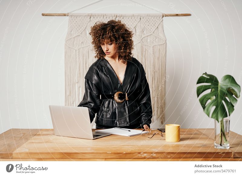 Vintage-Geschäftsfrau mit Laptop auf dem Tisch benutzend Büro Arbeit Leder Jacke sitzen retro Stil Outfit Frau Business cool Projekt Inbetriebnahme 80s Mode