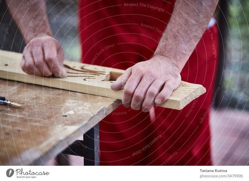 Nahaufnahme eines Tischlers mit männlichen Händen, der mit Schleifpapier Holzdetails abschleift. Zimmerer Schreinerei Handwerk Kunsthandwerker diy Industrie Job