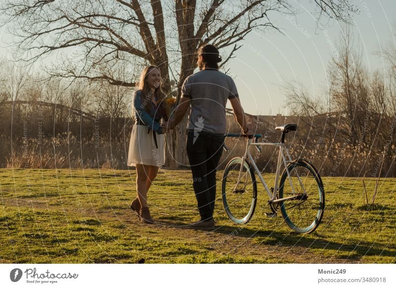 Verliebtes Paar beim Genießen im Park Mann Fahrrad Blumen Blumenstrauß Geschenk verliebt Freundin Valentinstag romantisch Romantik Erklärung Heirat Anfrage