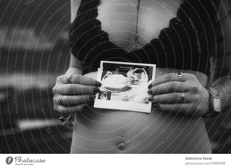 Schwangere Frau mit Sonogrammbild am Ufer Natur schwanger Liebe vorwegnehmen Eltern erwarten Harmonie Küste reisen pränatal Unterleib Bauch Bild Geburt Mutter
