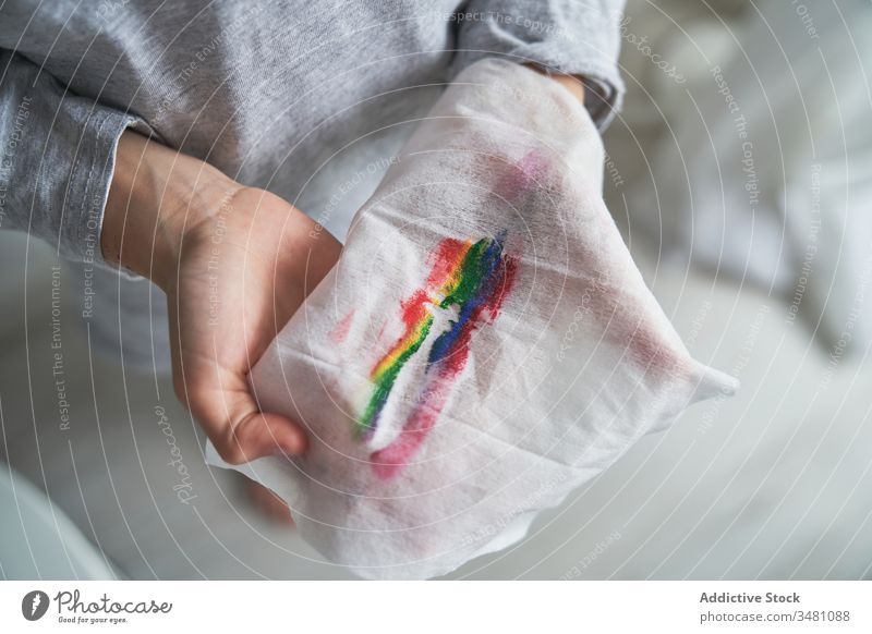 Anonymes Kind hält Tuch, während es Regenbogen-Make-up entfernt heimwärts Quarantäne Konzept Serviette zeigen Wischen Symbol Lächeln Pandemie Seuche entfernen
