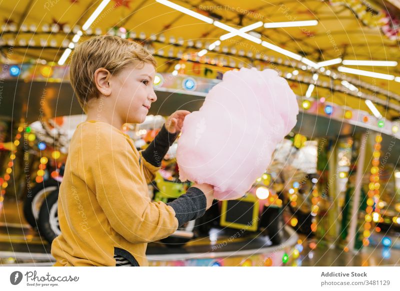 Junge isst Zuckerwatte auf Kirmes Jahrmarkt Lächeln Lichter Großstadt Fairness Entertainment Kind Glück urban süß Spaß erfreut Leckerbissen Lifestyle heiter