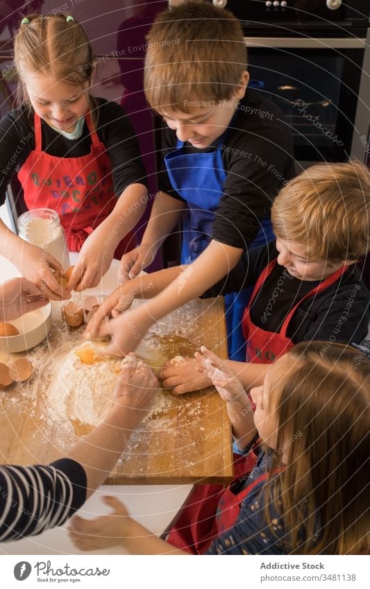 Kinder bereiten gemeinsam Teig zu Küche Koch Teigwaren Mehl Zusammensein Tisch vorbereiten Lebensmittel Schürze niedlich Bestandteil Spätzle Hilfsbereitschaft